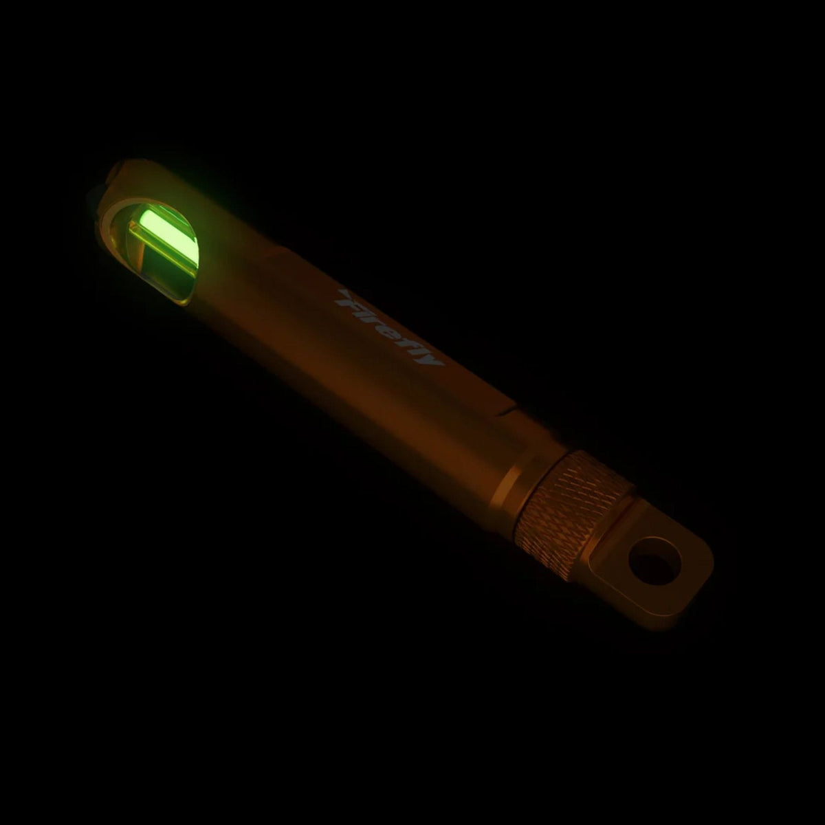 Firefly Champion Spark Marker showing green self-luminous tritium light glowing in darkness
