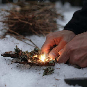 Ferrocerium fire starter producing sparks to ignite tinder during an outdoor demonstration