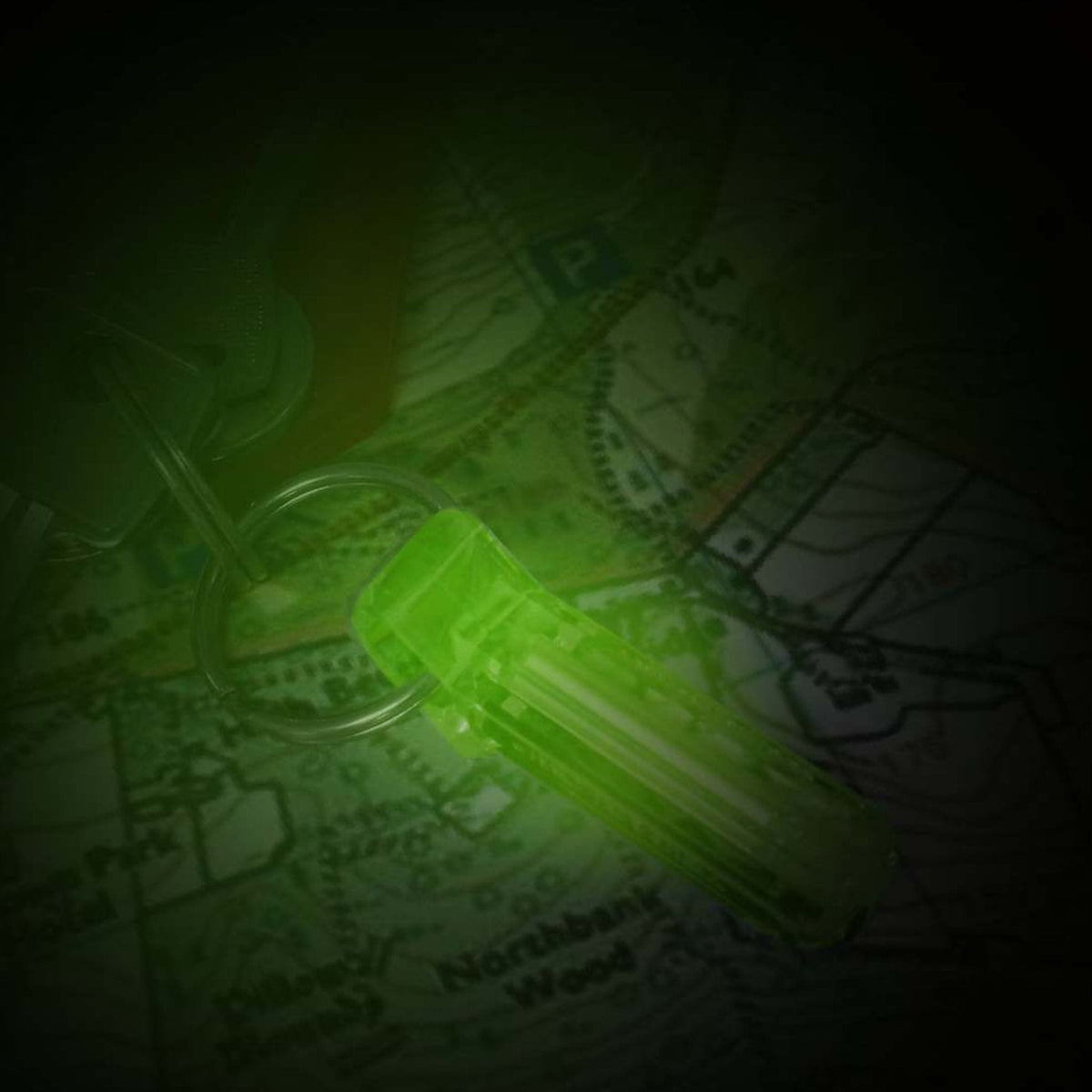 Green Firefly Flint-Glow Marker illuminating a map in a dark environment