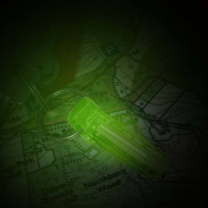 Green Firefly Flint-Glow Marker illuminating a map in a dark environment