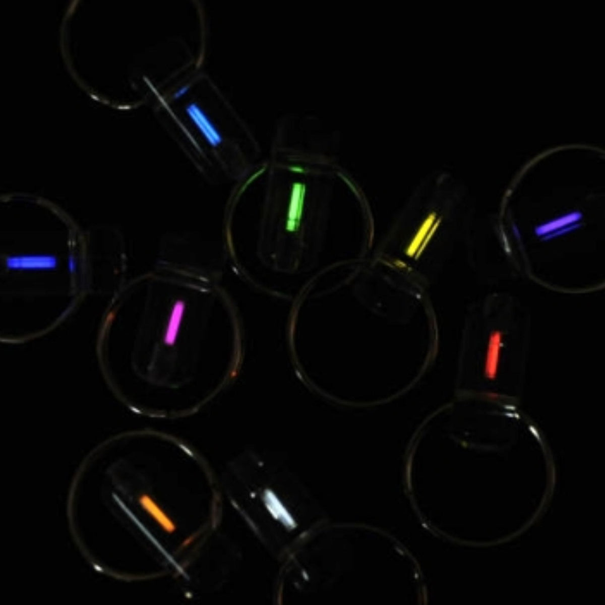 Assorted Firefly tritium zip markers glowing in different colours against a black background