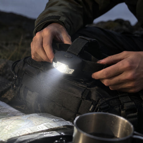 Hands adjusting a bright Rothco Deluxe 5-bulb headtorch outdoors
